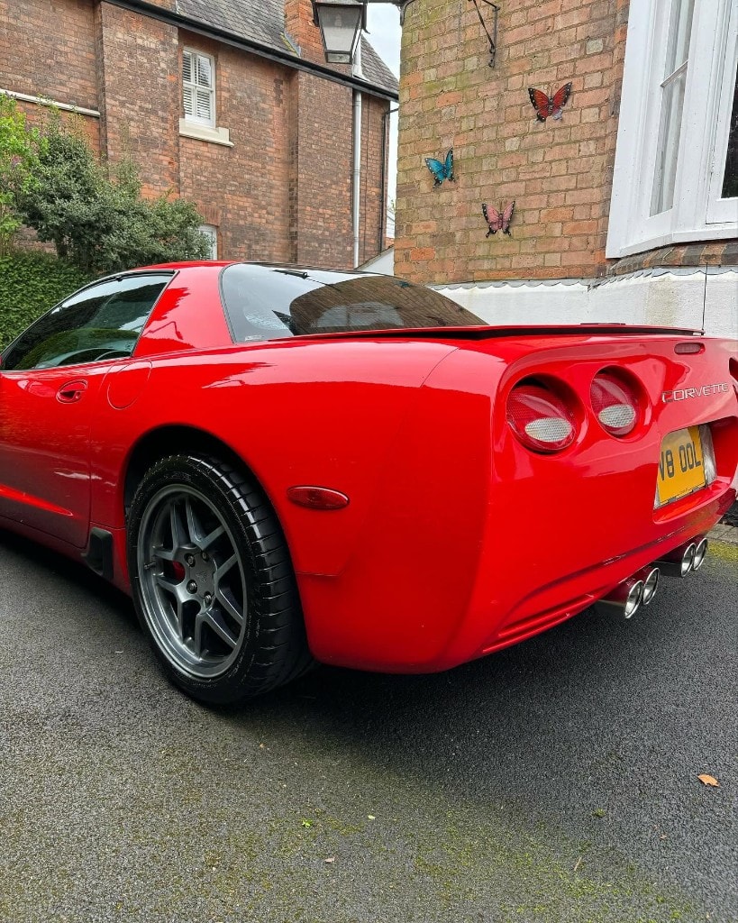 Red C5 Corvette rear three-quarter with a mirror shine
