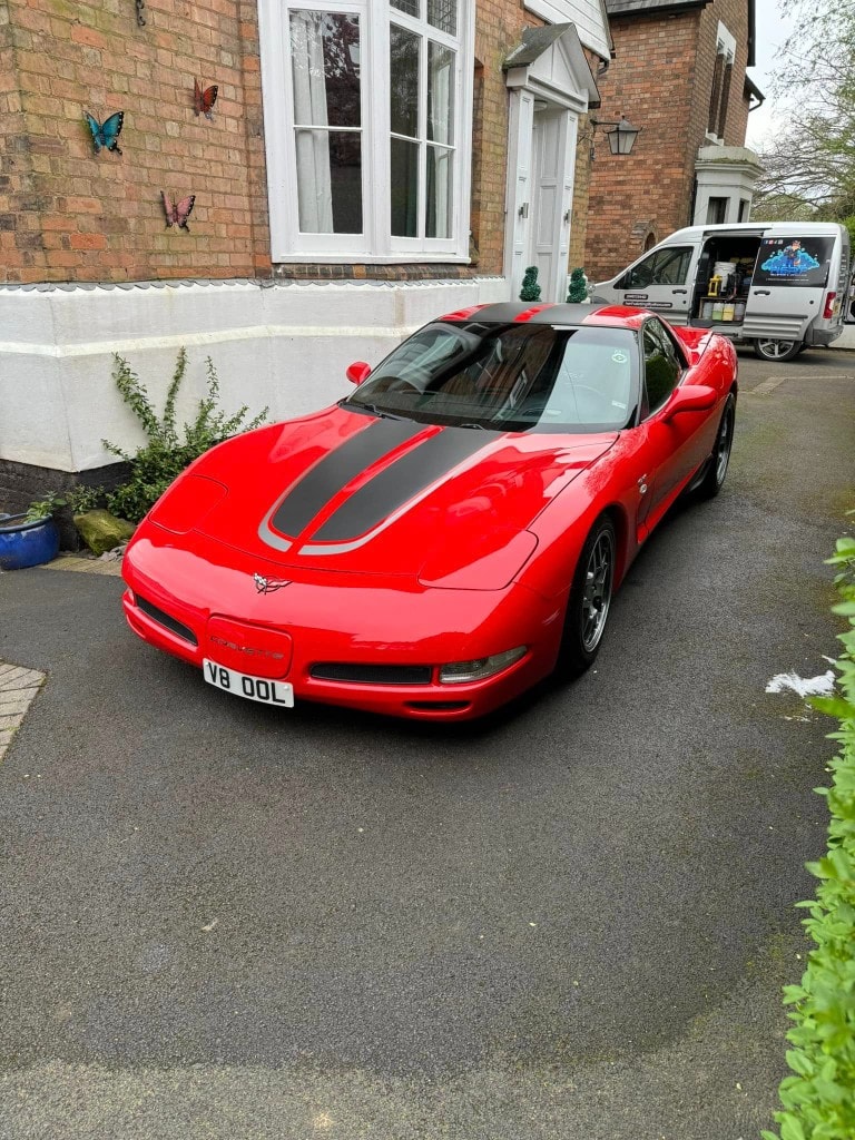 Red C5 Corvette with racing stripes, freshly detailed
