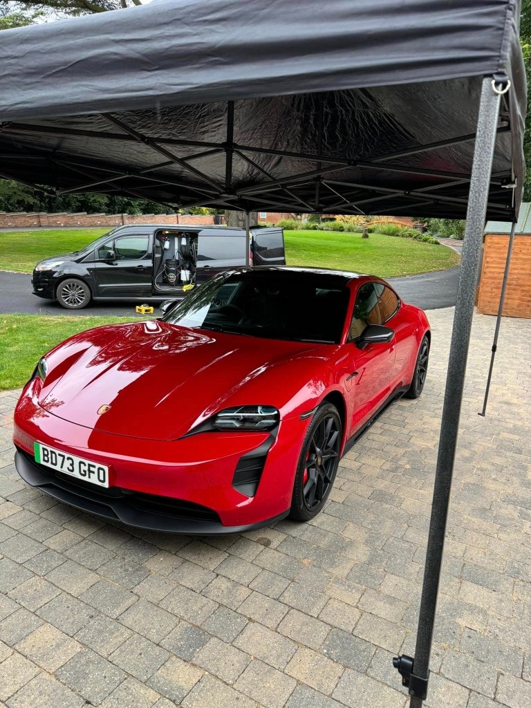 Red Porsche Taycan detailed under the HERF gazebo